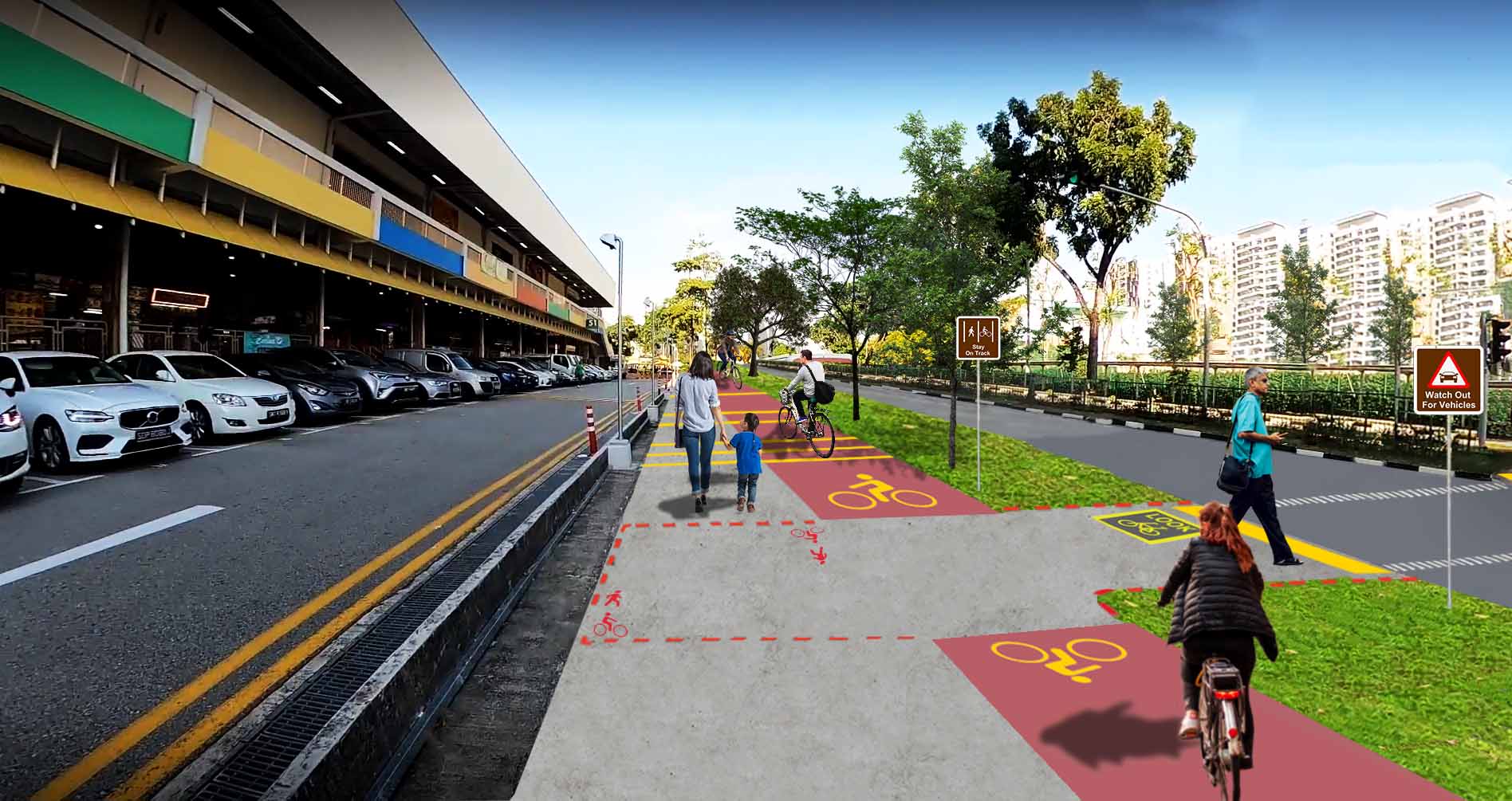 A mixed-use pathway with cyclists and pedestrians alongside a road with parked cars, featuring wayfinding signage and traffic signals.